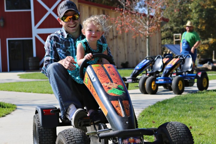 father and child riding on cart